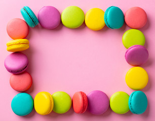 Macaroons dessert on blue background. Frame composition. Copy space. Top view.
