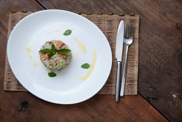 Tartar salmon with herbs on white dish