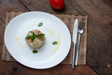 Tartar salmon with herbs on white dish