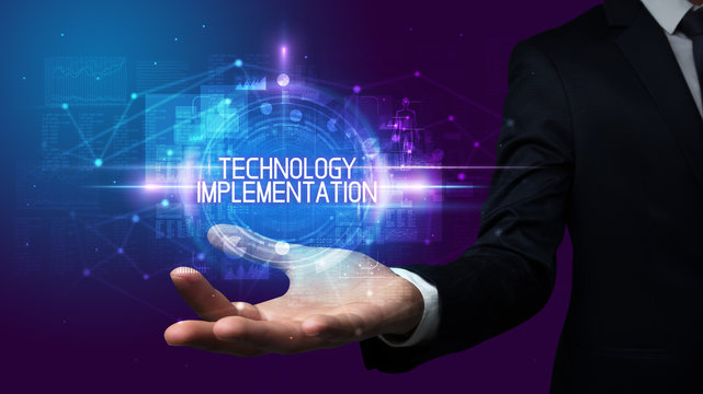 Man hand holding TECHNOLOGY IMPLEMENTATION inscription, technology concept