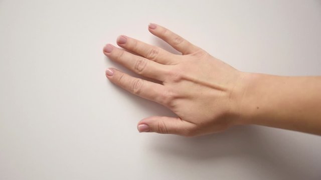 Female hand erases something from the wall