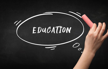 Hand drawing EDUCATION inscription with white chalk on blackboard, education concept