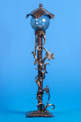 Fototapeta na wymiar Exclusive forged street lamp on a blue background