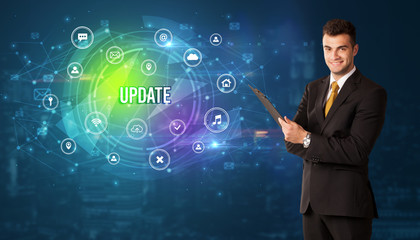 Businessman thinking in front of technology related icons and UPDATE inscription, modern technology concept