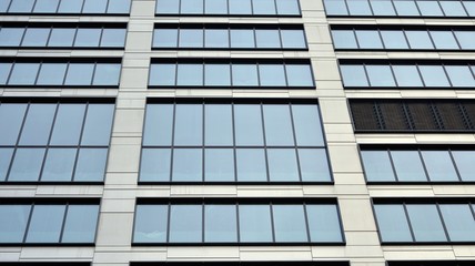 Modern office building detail, glass surface with sunlight