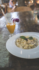 Yummy pasta on cafe table. Closeup plate with portion of tasty pasta with cream sauce placed on table in restaurant