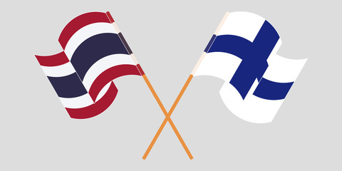 Crossed and waving flags of Thailand and Finland