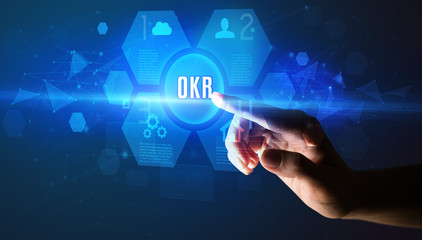 Hand touching OKR inscription, new technology concept