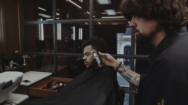 Haircut of a man in a vintage brown glass barber shop. 