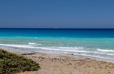 Gravel / pebble beach at the southwest coast of Rhodes island near Apolakkia with multi colored ocean water