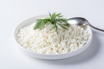 Cottage cheese in a plate isolated on a white background.