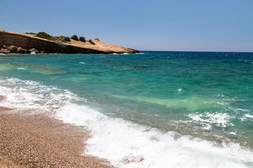 Gravel / pebble beach Akra Fourni nearby Monolithos  at Rhodes island with multi colored ocean water and rocks