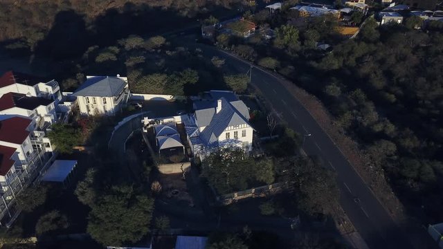 4K aerial Windhoek capital residential central hilly district bright sunset drone video with upmarket houses and old white walls German mansion on top of hill in Khomas Region, central Namibia