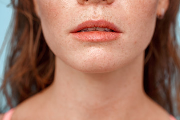 Summer Freestyle. Young woman with freckles standing isolated on blue breathing close-up