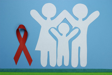 Red Ribbon and Paper silhouette of family. AIDS awareness symbol