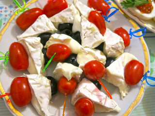 appetizer on skewers of cheese, olives and tomatoes