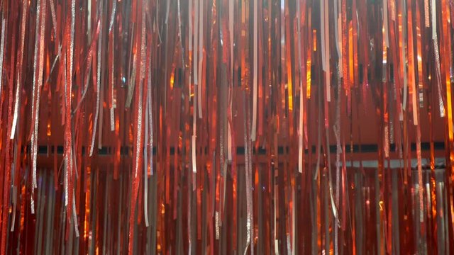 Red ribbon hanging on the wall with decorative lights in the background