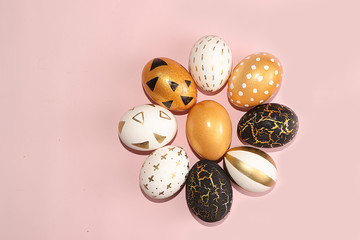 Decorated golden easter eggs isolated on pink background. Minimal holiday concept. Happy easter background. Creative painting of eggs at home.