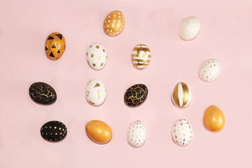 Decorated golden easter eggs isolated on pink background. Minimal holiday concept. Happy easter background. Creative painting of eggs at home.