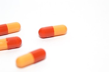 Red and orange capsules isolated on white background