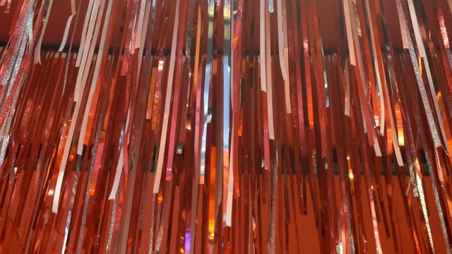 Red ribbon hanging on the wall with decorative lights in the background