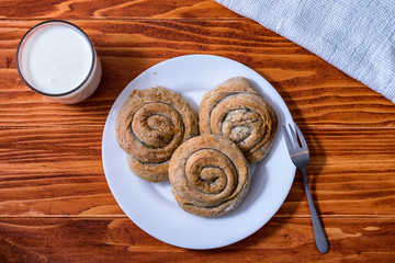 Domestic Home made Rolled pastry with spinach and cheese on a napkin with a glass of Yogurt