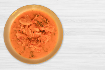 Braised Fish Fillet or Stew fish. Cooked fish made with tomatoes, onions, peppers and coriander. White wood background