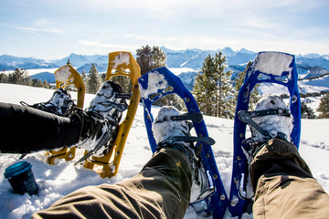 point of view of snow shoes, sitting in the snow in front of mountain panorama