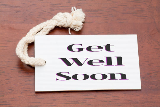 Get well soon words printed on a whitepaper tag or label on wood