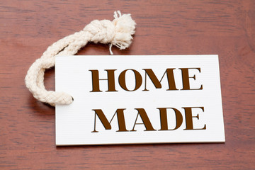 Home Made words printed on a whitepaper tag or label on wood