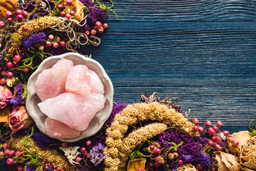 Rose Quartz with Dried Flowers and Moss on Blue Background