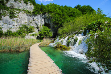 Wooden pathway swirling around a small waterfall in the Plitvice Lakes National Park in Croatia