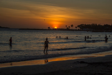 Fototapeta na wymiar People swimming in sunset