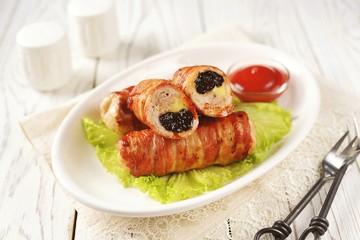 Pork rolls with prunes and cheese in bacon.