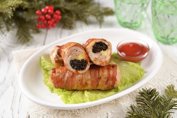Pork rolls with prunes and cheese in bacon.