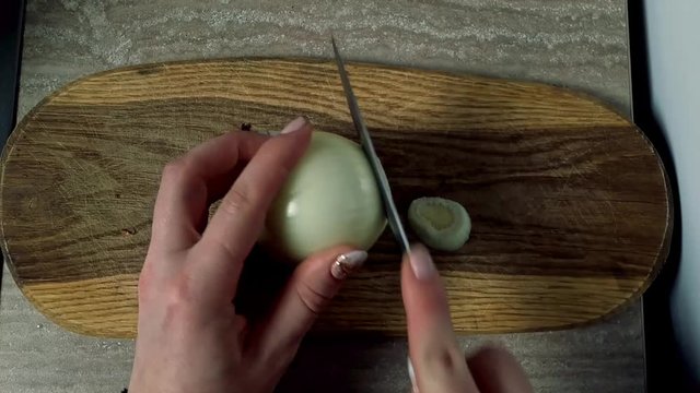 Dicing sweet onions on a wooden board quickly, top down shot 
