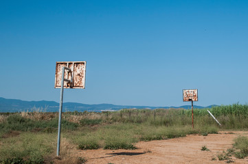 Grunge basketball board with hoop on abandoned basketball court in the beach © varbenov