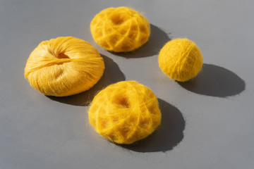  Yellow skeins of yarn of alpaca wool on a grey table. Side view