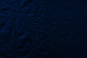 Texture of crumpled black fabric with a blue tint. Creative vintage background. Black flag.