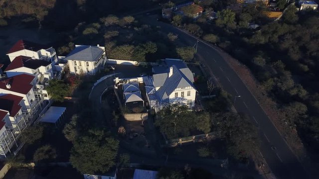 4K aerial Windhoek capital residential central hilly district bright sunset drone video with upmarket houses and old white walls German mansion on top of hill in Khomas Region, central Namibia