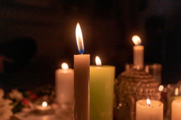 Mandala made of burning candles, flowers, a grishna idol in the dark