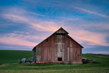 Obraz premium Sunset behind old barn in Palouse region of Washington State
