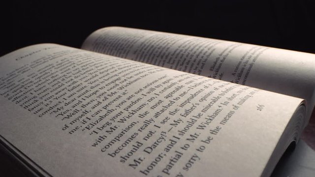 Slow push in across the surface of an open book at an angle with probe lens