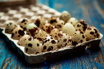 a small quail egg, on a blue, wooden,old, shabby background