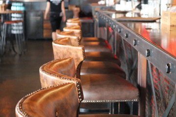 Inspired by Steampunk design, distressed leather bar stools a bar of an empty pub