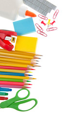 School supplies, pencils scissors, sticky notes, stapler, staples, glue, paper clips and tacks on a white background.