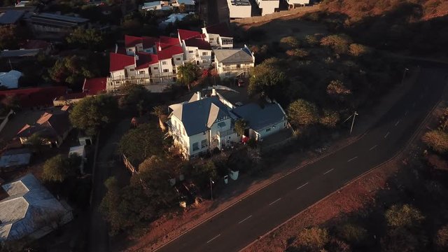 4K aerial Windhoek capital residential central hilly district bright sunset drone video with upmarket houses and old white walls German mansion on top of hill in Khomas Region, central Namibia