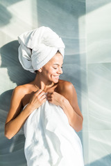Beautiful young healthy woman relaxing in a robe after shower at home