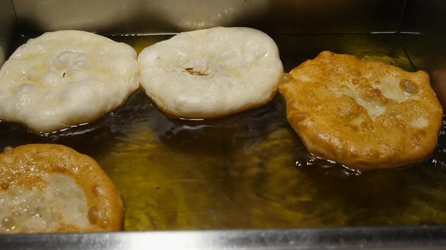 Preparation of Langos, Hungarian food speciality, a deep fried dough