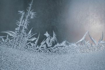 frosty patterns on the window glass closeup. natural textures and backgrounds. ice patterns on...
